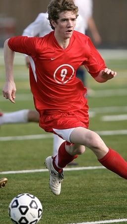 joueur de football courant avec un ballon
