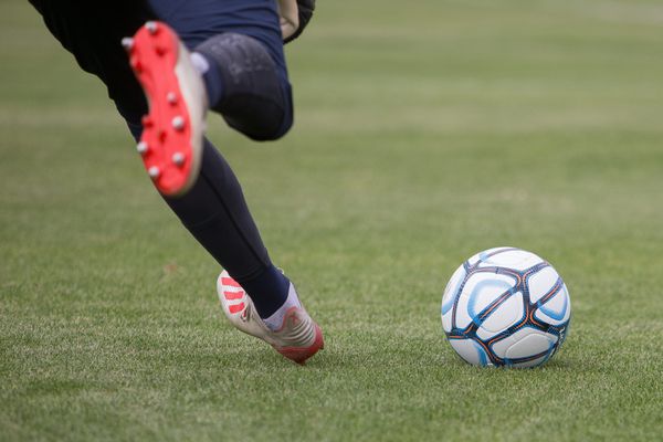 image d'un homme tirant un ballon de football